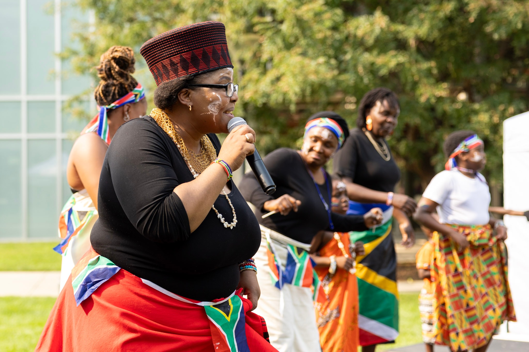 Women in South African attire singing and dancing together at the festival